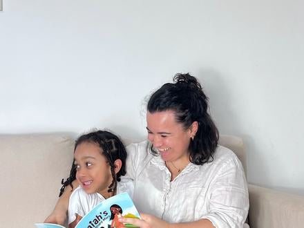 A parent and child reading a Little Omo picture book together